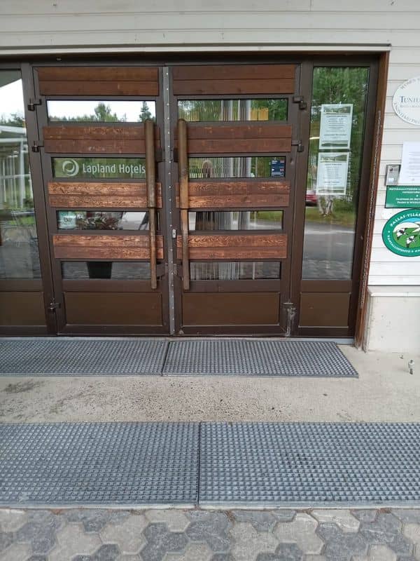 Two brown doors with two long vertical wooden handles either side